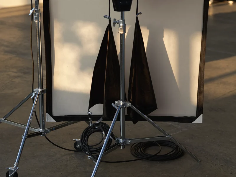 Illustration: Studiolicht-Equipment mit Softbox, Lichtstativ, Blenden und aufgerollten Kabeln